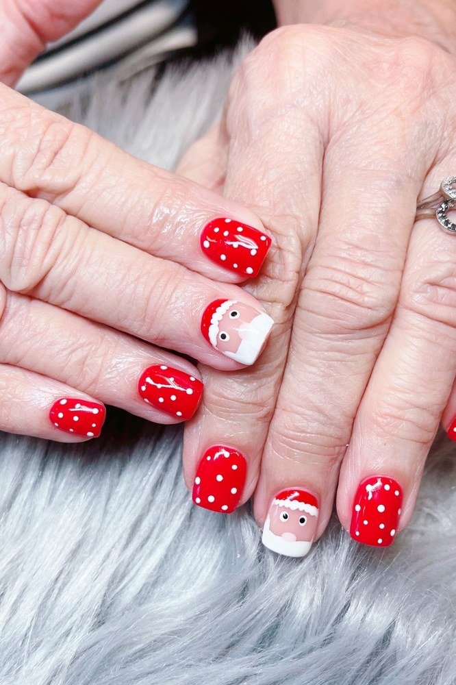 Red dots with snowman accent, mature hands - Christmas nail design for older women