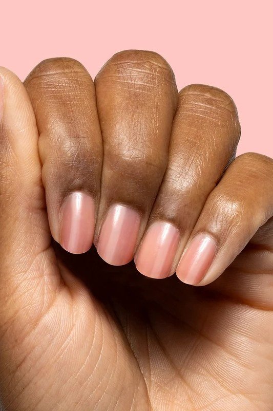 Nude nails on pink background with fist pose