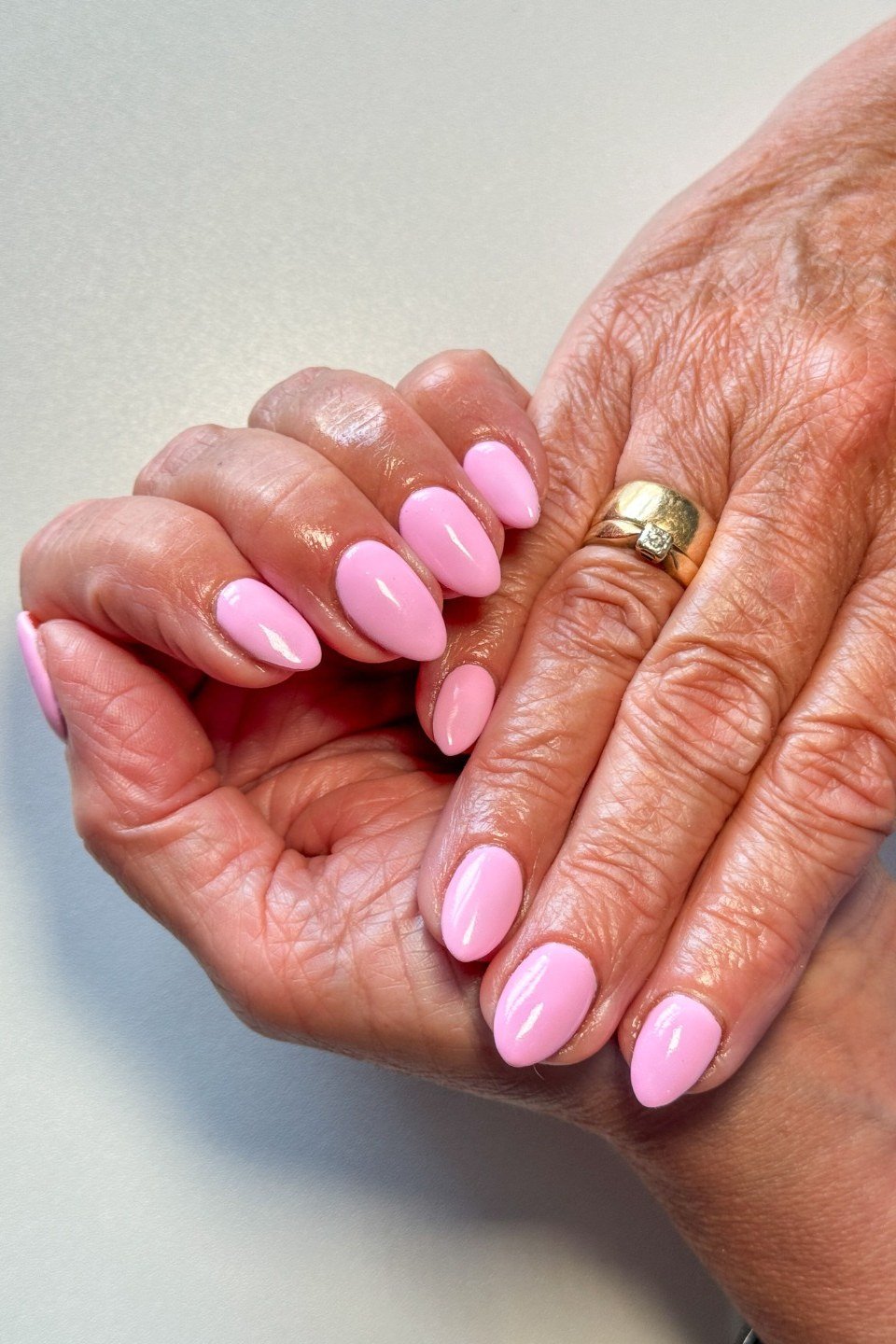 Soft pink short nails on elderly hands