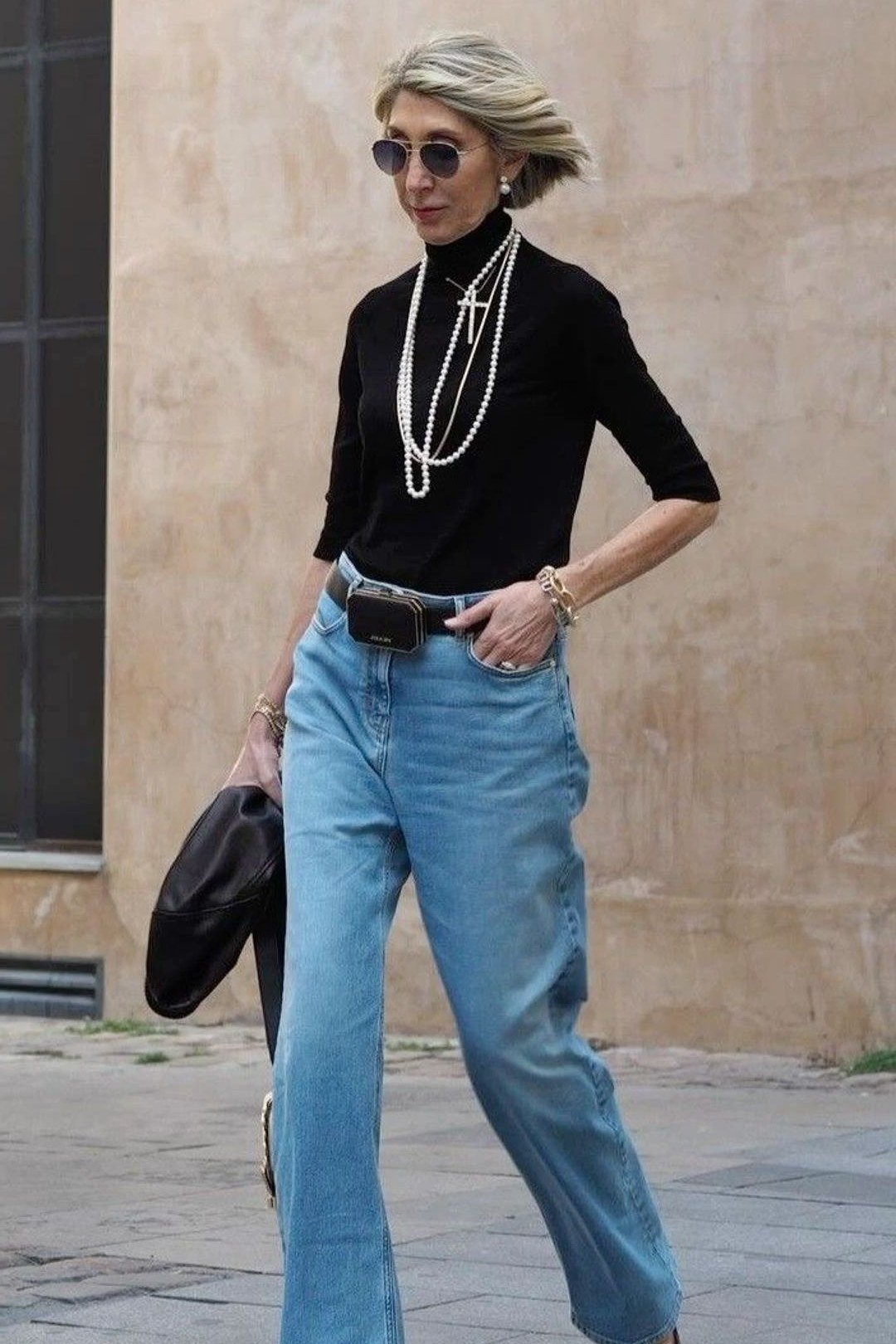 Black turtleneck with light wide-leg jeans and layered necklaces, fall outfit for women over 50