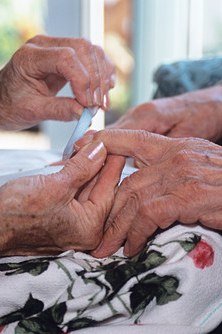 Professional manicure on mature hands at a nail salon
