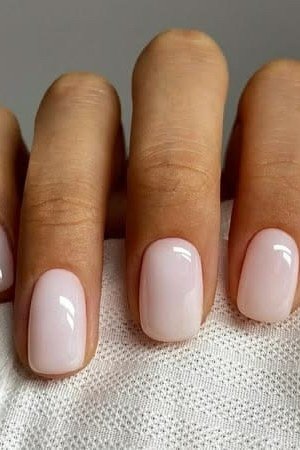 Milky white nude nails on brown skin