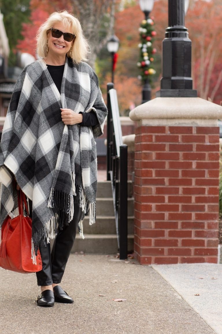 Black and white buffalo plaid shawl with black leggings and red handbag