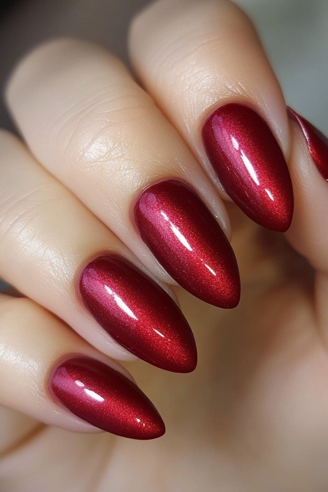 Metallic red chrome almond gel nails, glowing fall red manicure