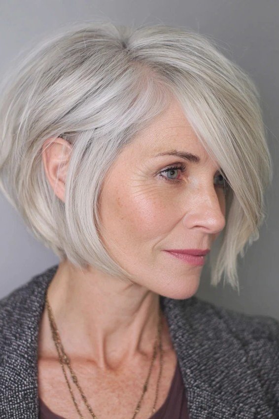 Silver angled pixie-bob with longer front - trendy short haircut for older women with fine hair
