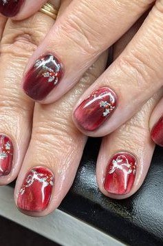 Nail art design for women over 60: burgundy nails with white floral art