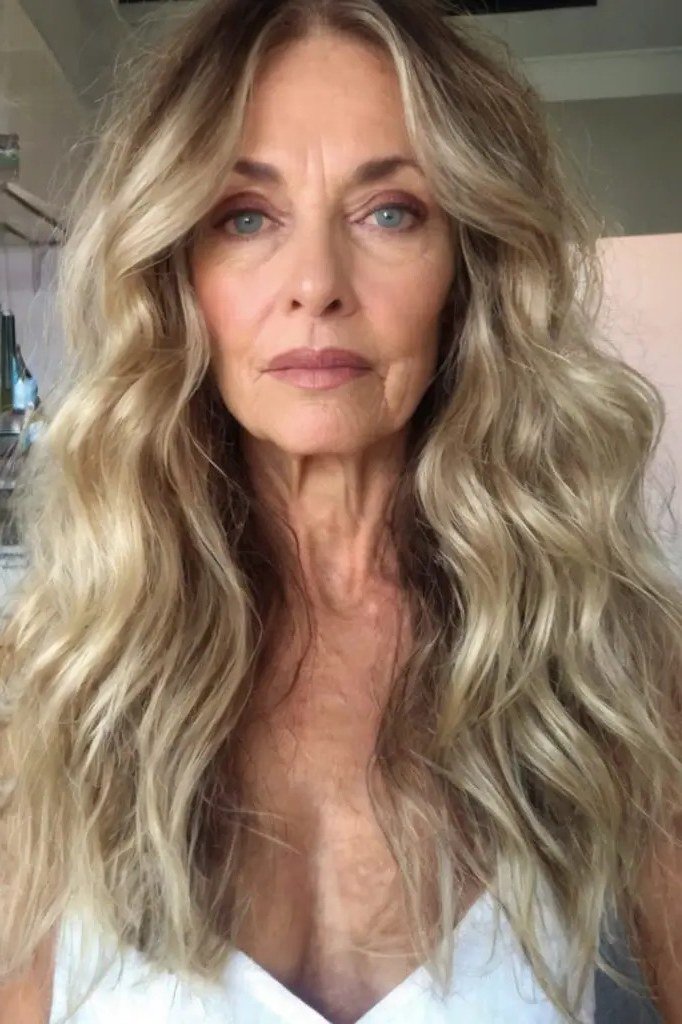 Long gray-blonde loose waves with center part for women over 50