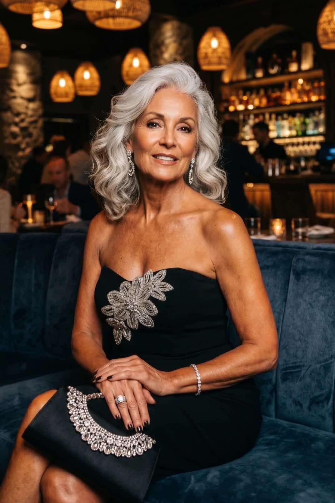Black strapless cocktail dress with brooch, seated restaurant, chic night out outfit for women over 50