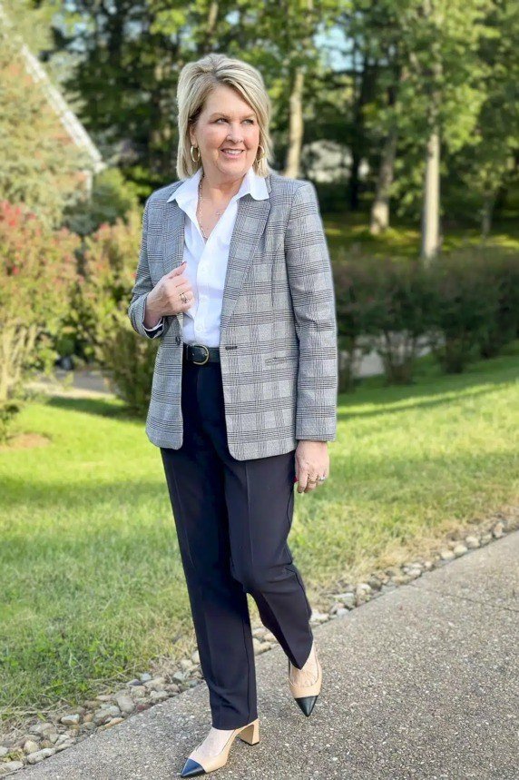 Grey plaid blazer navy trousers, blonde woman in park - business casual work outfit for women over 50