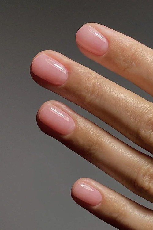 Pink nude short nails on grey background