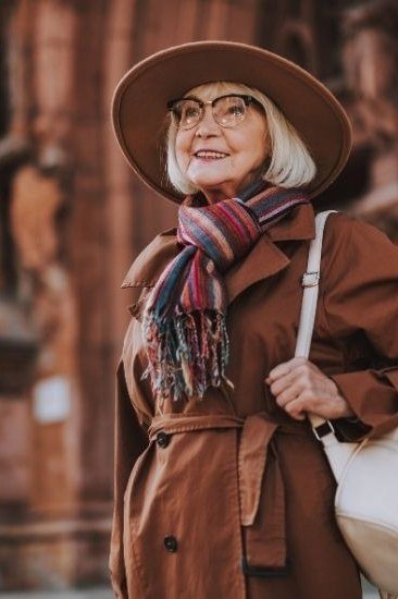 Rust wool coat with plaid scarf and brown wide-brim hat, close-up