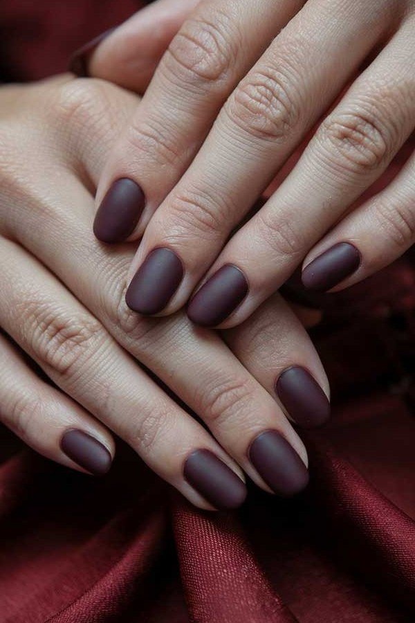 Moody matte dark plum nails for women over 50