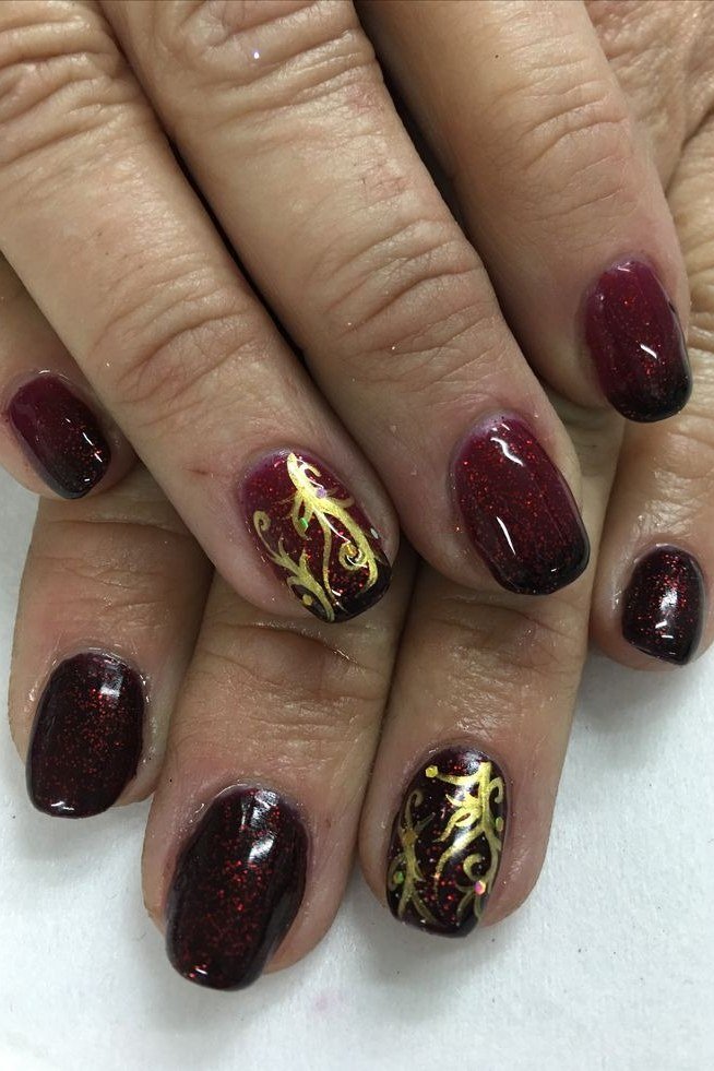 Nail art design for women over 60: burgundy nails with gold foil accent