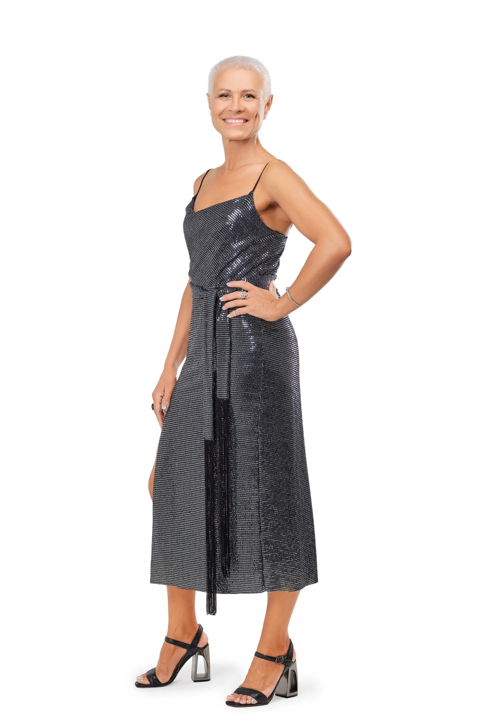 Gray-haired woman in charcoal metallic slip midi dress with strappy heels