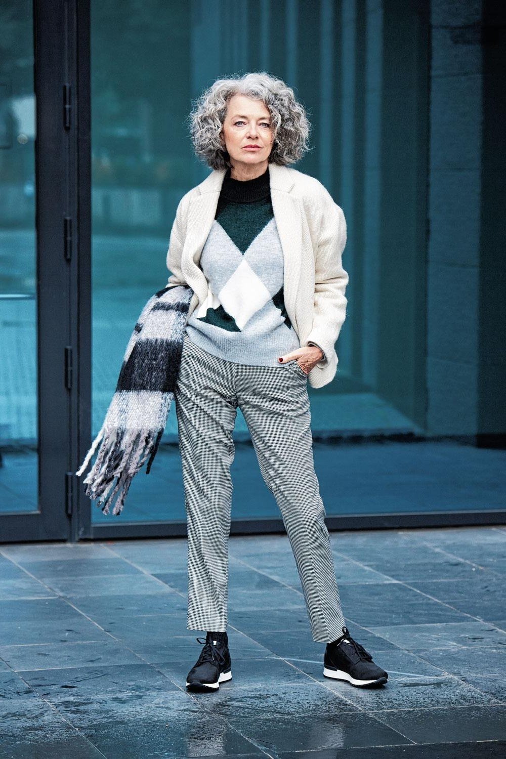 Grey argyle sweater vest over white shirt with grey trousers and sneakers, cozy sweater outfit idea for women over 70