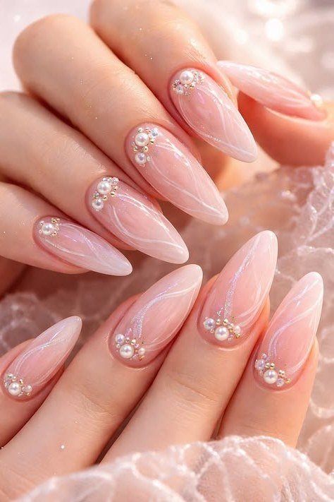 Pink almond nails with pearl swirls and rhinestones