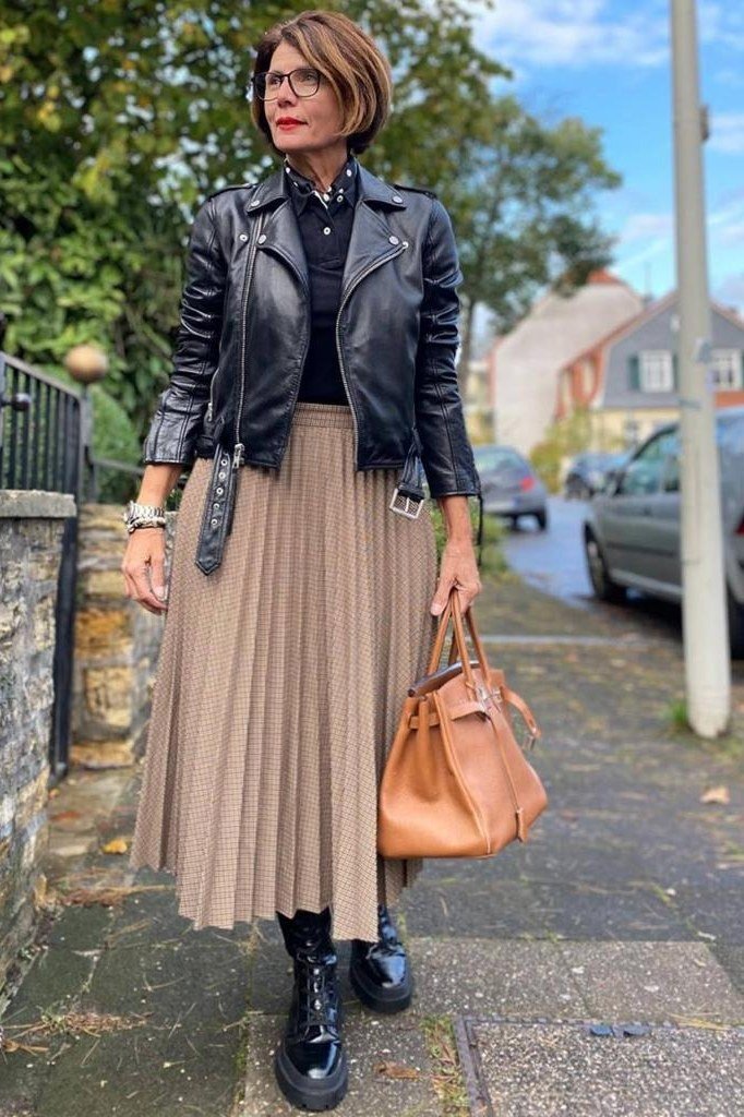 Black leather jacket with pleated tan midi skirt fall outfit idea for women over 60