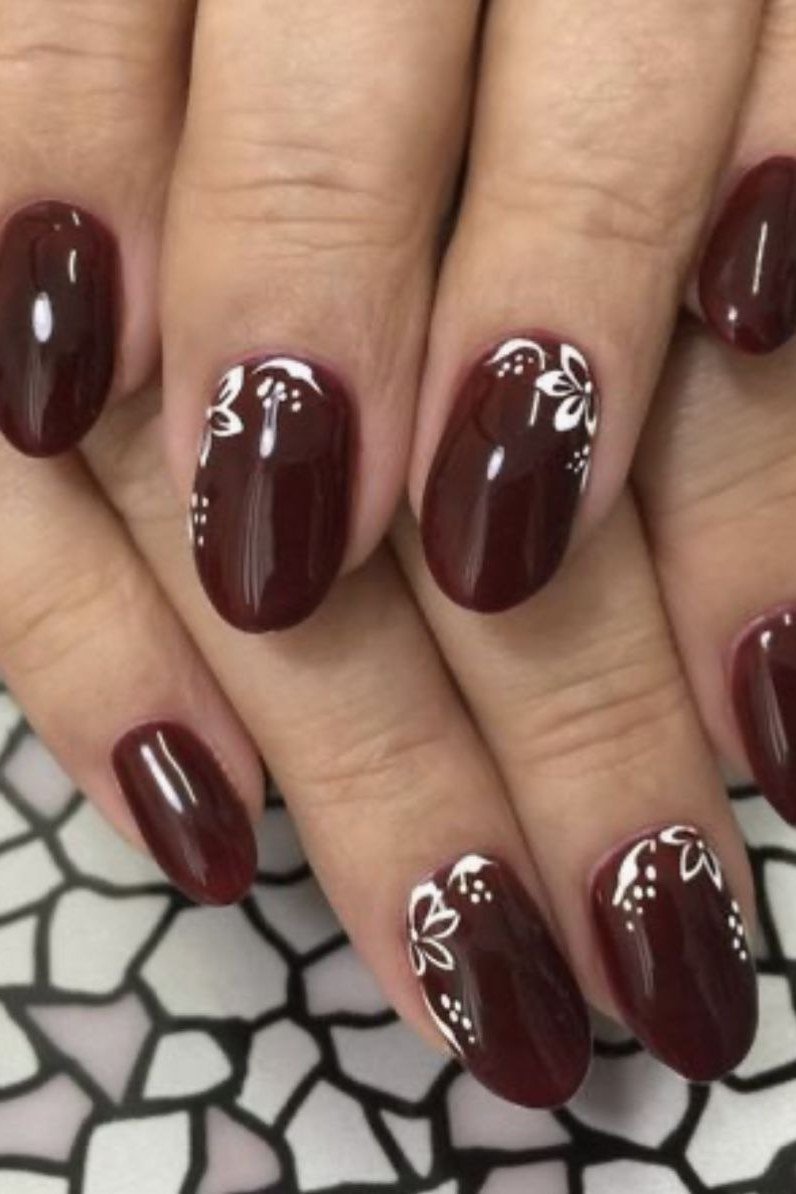 Nail art design for women over 60: burgundy nails with white floral art