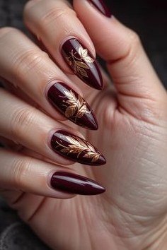 Gold art on burgundy stiletto, burgundy fall nail idea for women over 60