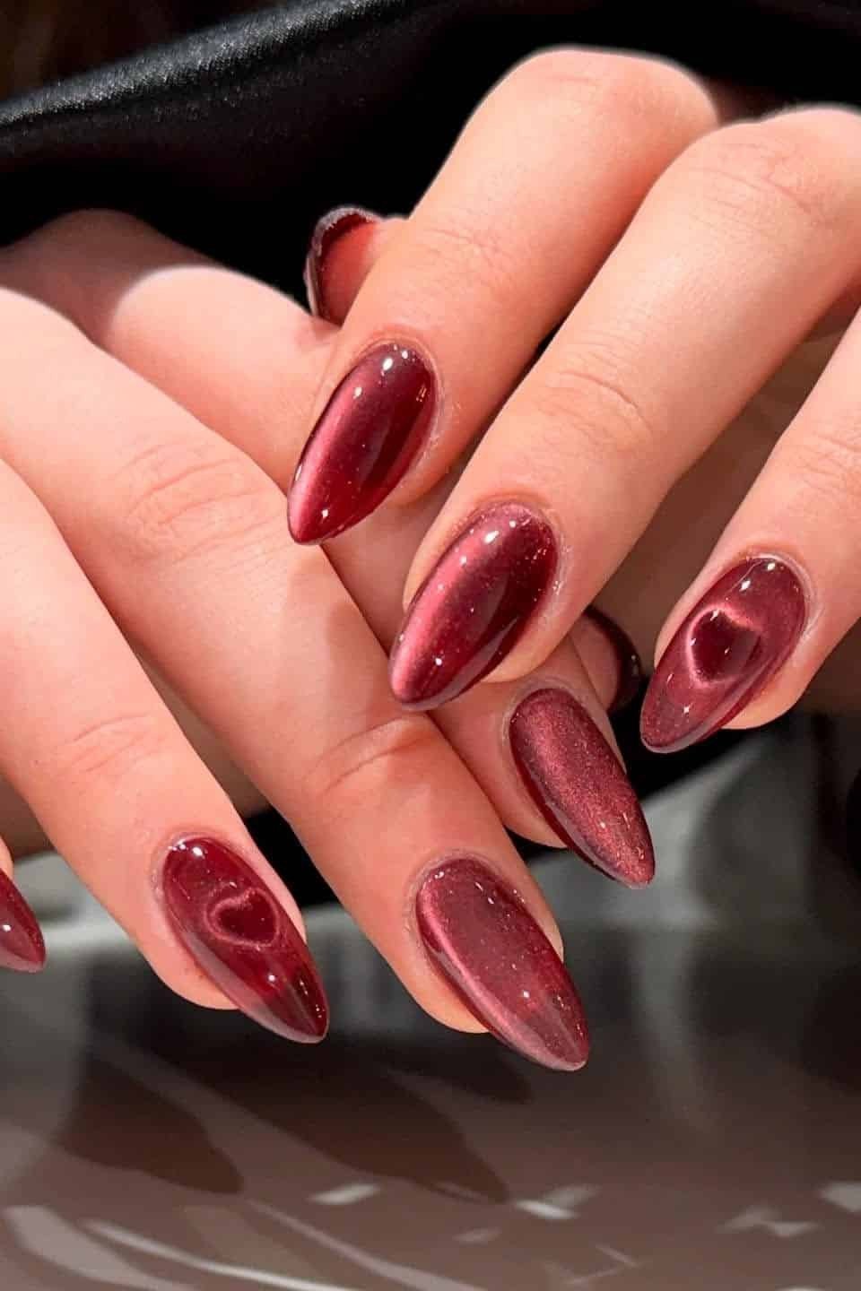 Cherry Red Cat Eye Nails - Vivid cherry red with glowing magnetic shimmer covers these long almond nails.