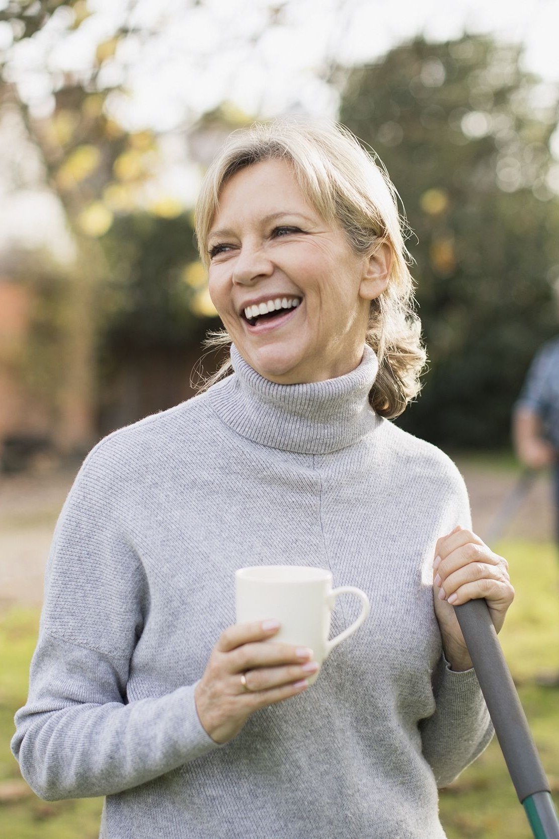 Soft grey turtleneck sweater in garden with coffee, relaxed October outfit over 50