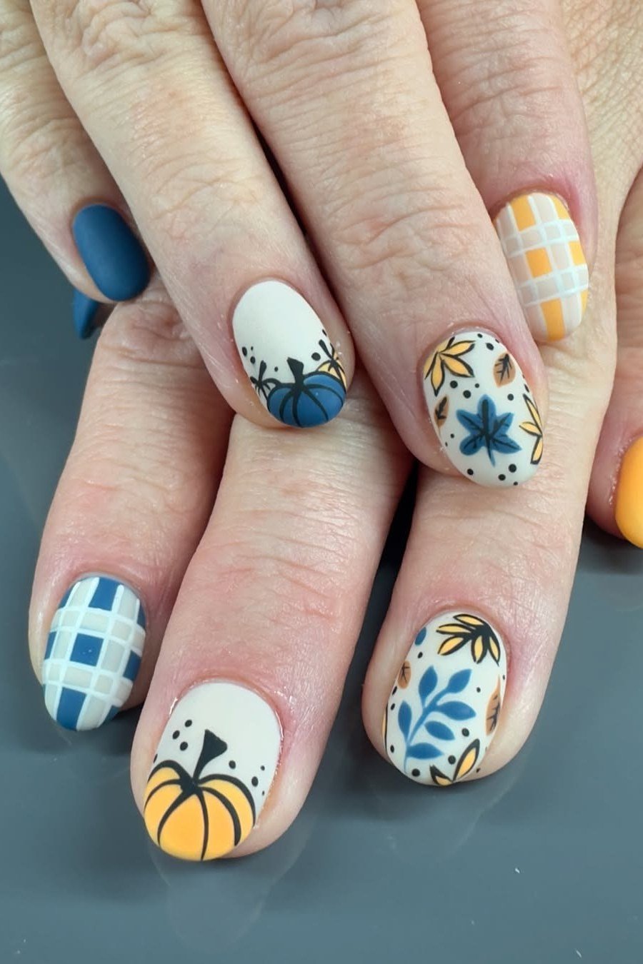 Pumpkin and plaid nail art on warm fall gel nails, autumn harvest manicure