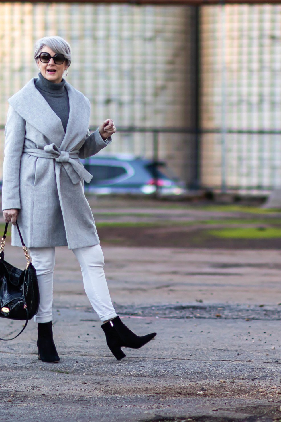 Light gray belted wrap coat with white jeans for women over 50