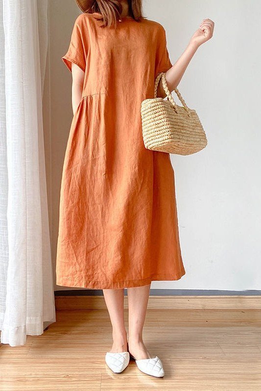 Rust tiered midi dress with straw tote, bright interior for women over 60