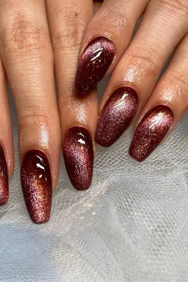 Burgundy Glitter Cat Eye Nails - Deep burgundy with sparkling glitter and magnetic shimmer covers these long almond nails.