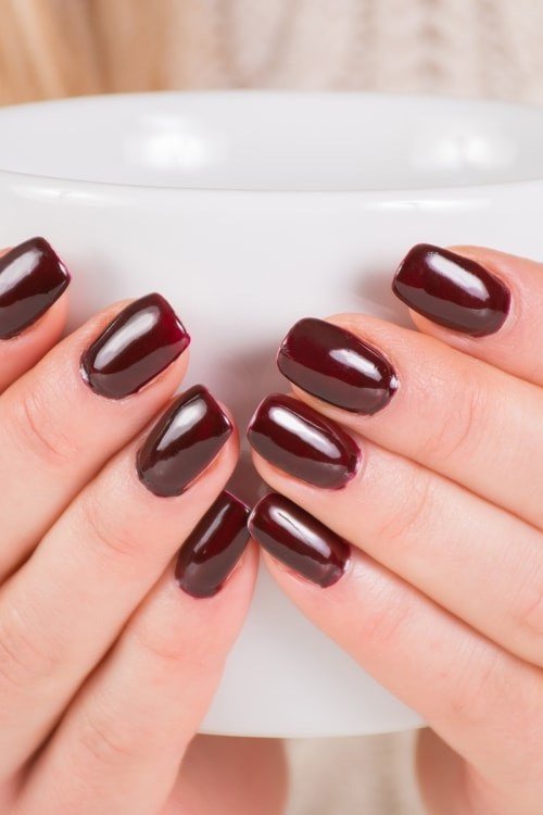 Dark Plum Nails with a White Mug, fall nail color idea for women over 50