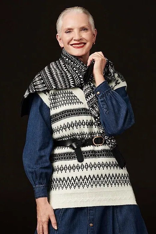 Black-and-white fair-isle knit vest layered over denim dress, cozy sweater outfit idea for women over 70