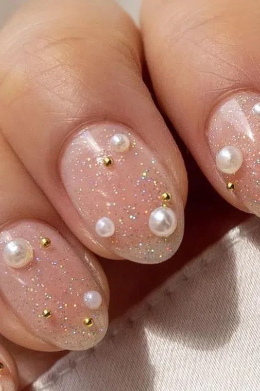 Nude nails with gold beads and pearl nail art