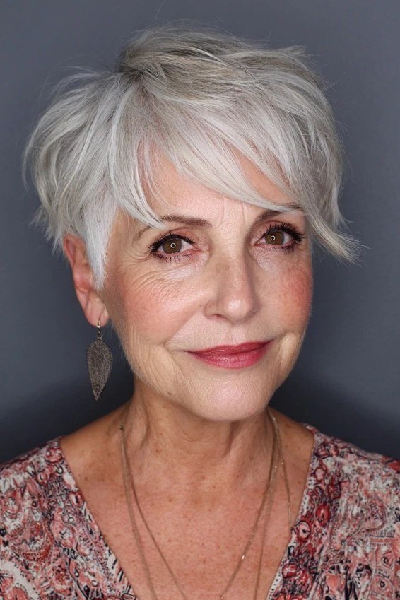 Silver choppy pixie with side swept bangs for women over 60, front view