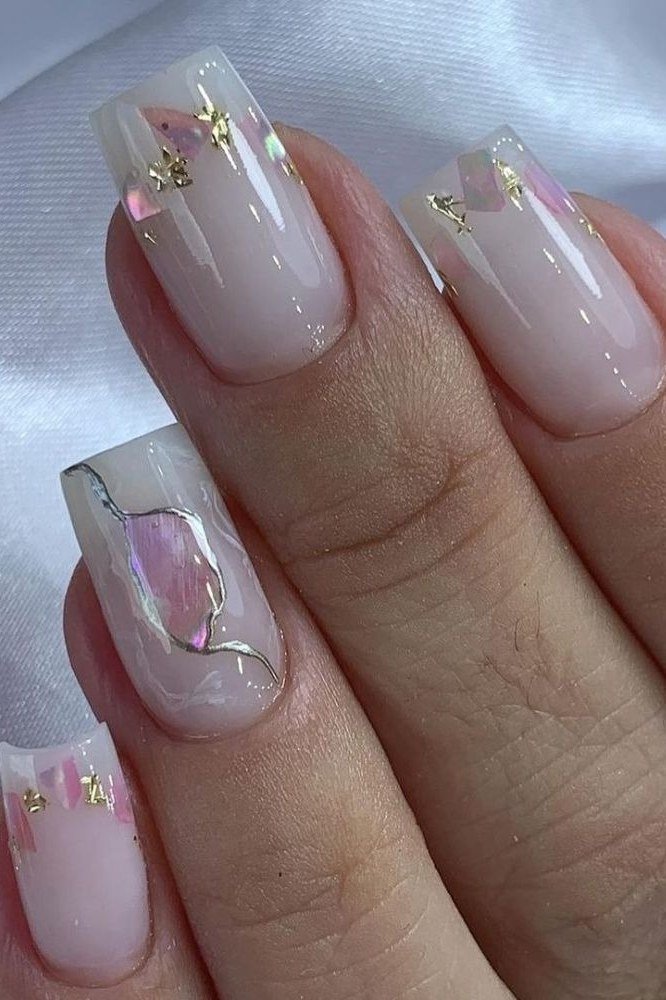 Milky white nails with a small pink heart accent