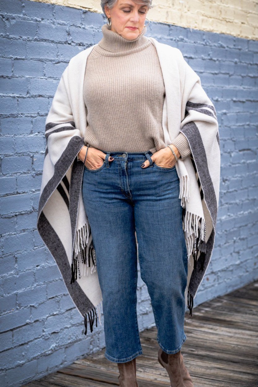 Beige turtleneck with cream shawl, blue jeans and taupe booties