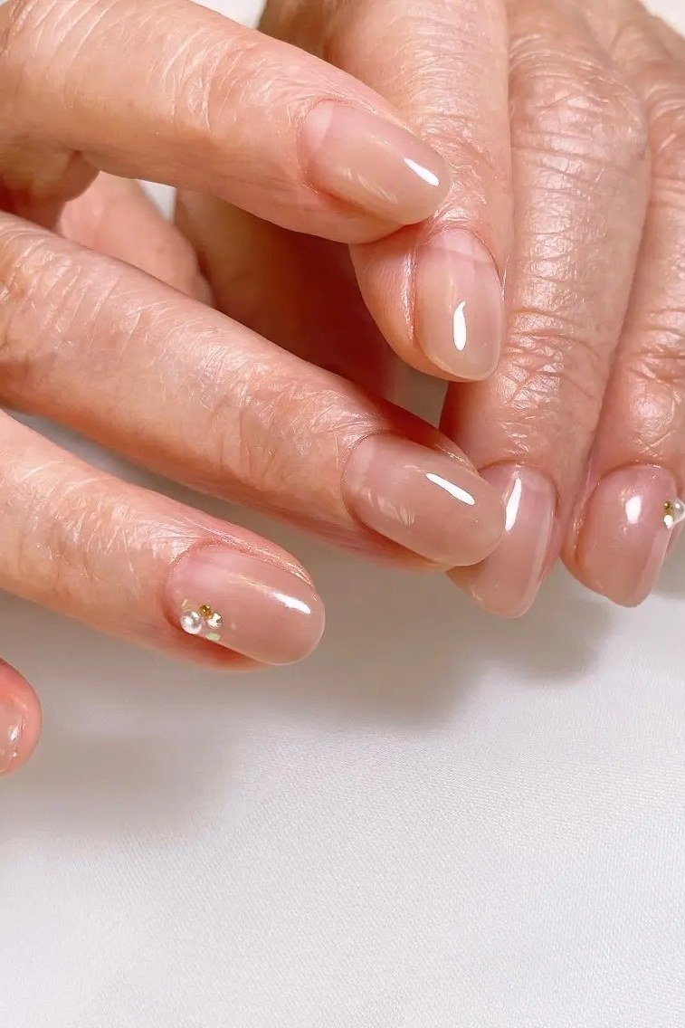 sheer nude oval gel nails with micro gems at cuticles, gemstone nail art for older women