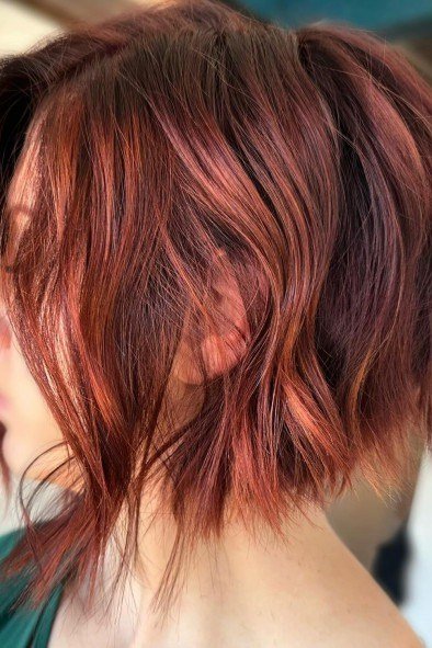 deep red wavy layered bob, side view — chin-length layered bob hairstyle for women over 50