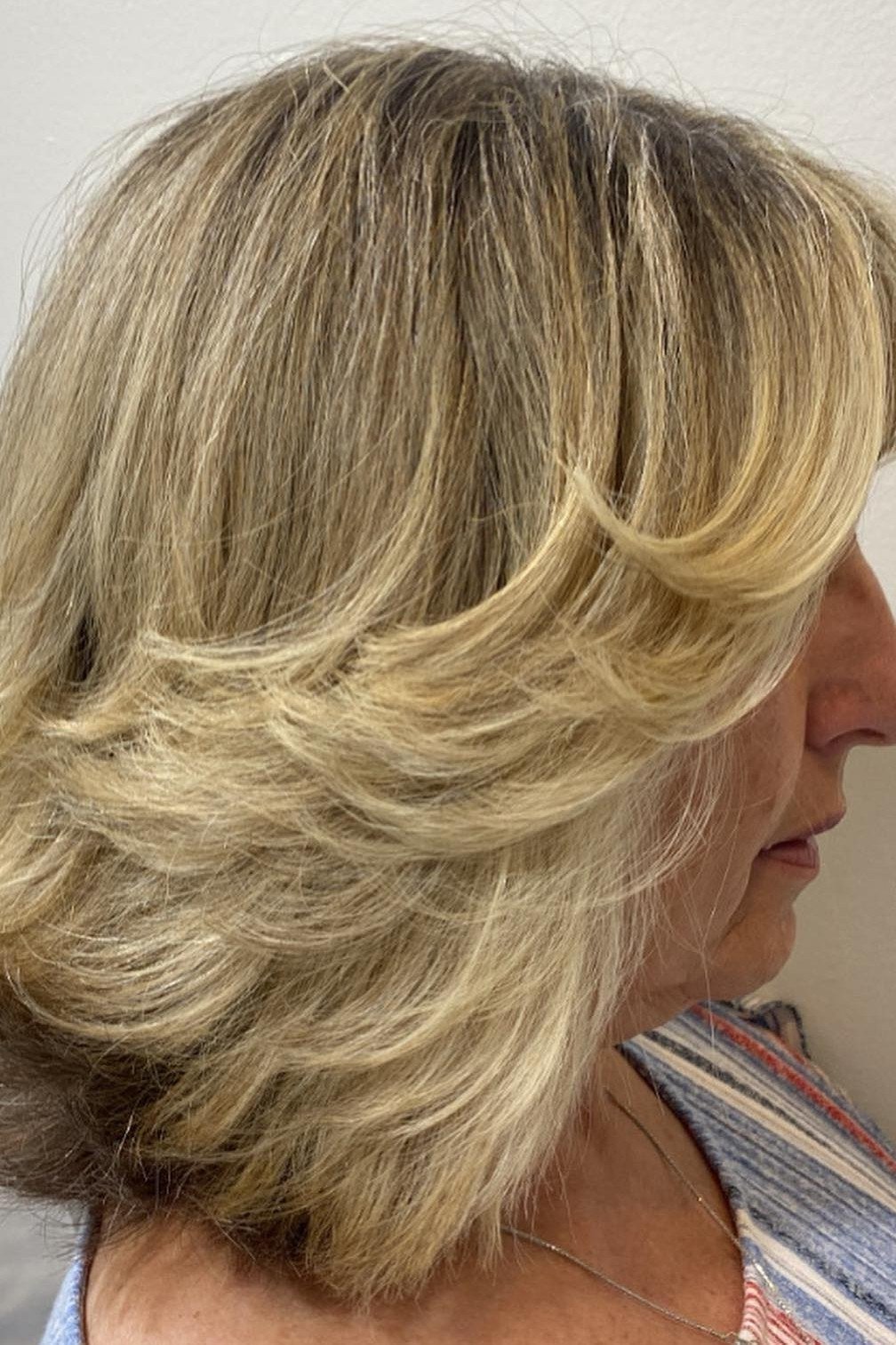 Blonde feathered bob with bouncy blowout layers for women over 60