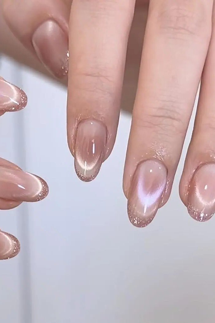 Milky Nude Cat Eye Nails - Sheer milky nude with a soft magnetic glow covers these medium length almond nails.