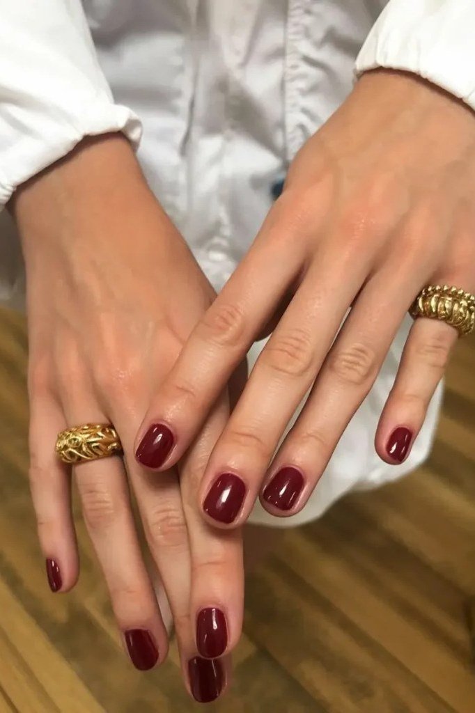 Short burgundy oval nails with a rich glossy finish, simple elegant fall color.