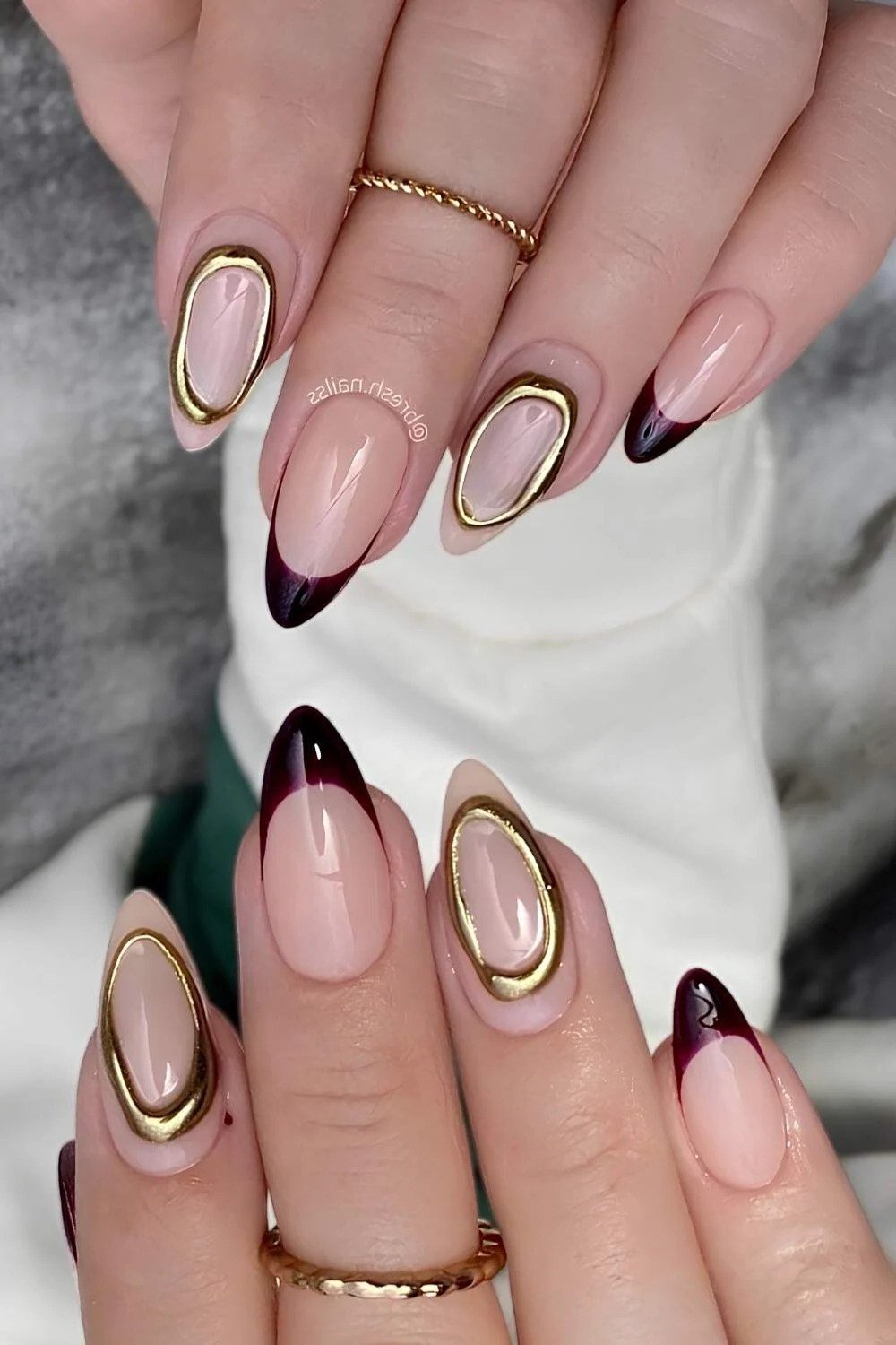 Nude almond gel nails with gold frame art and burgundy French tips, luxe fall design