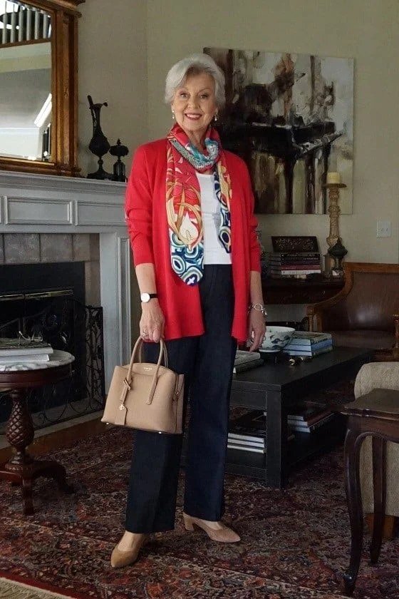 Woman over 50 wearing red cardigan with printed scarf and black pants, everyday casual outfit idea