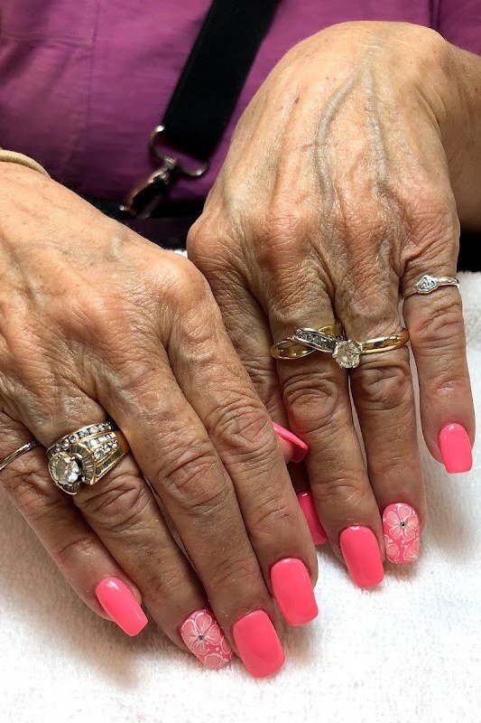 coral pink short glossy nails on elderly hands