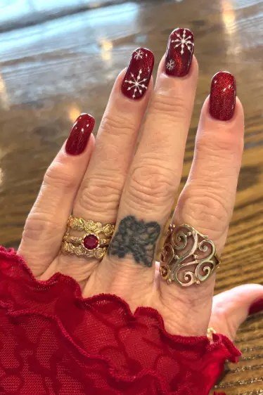 Red glitter with white snowflake, red lace sleeve - Christmas nail design for older women