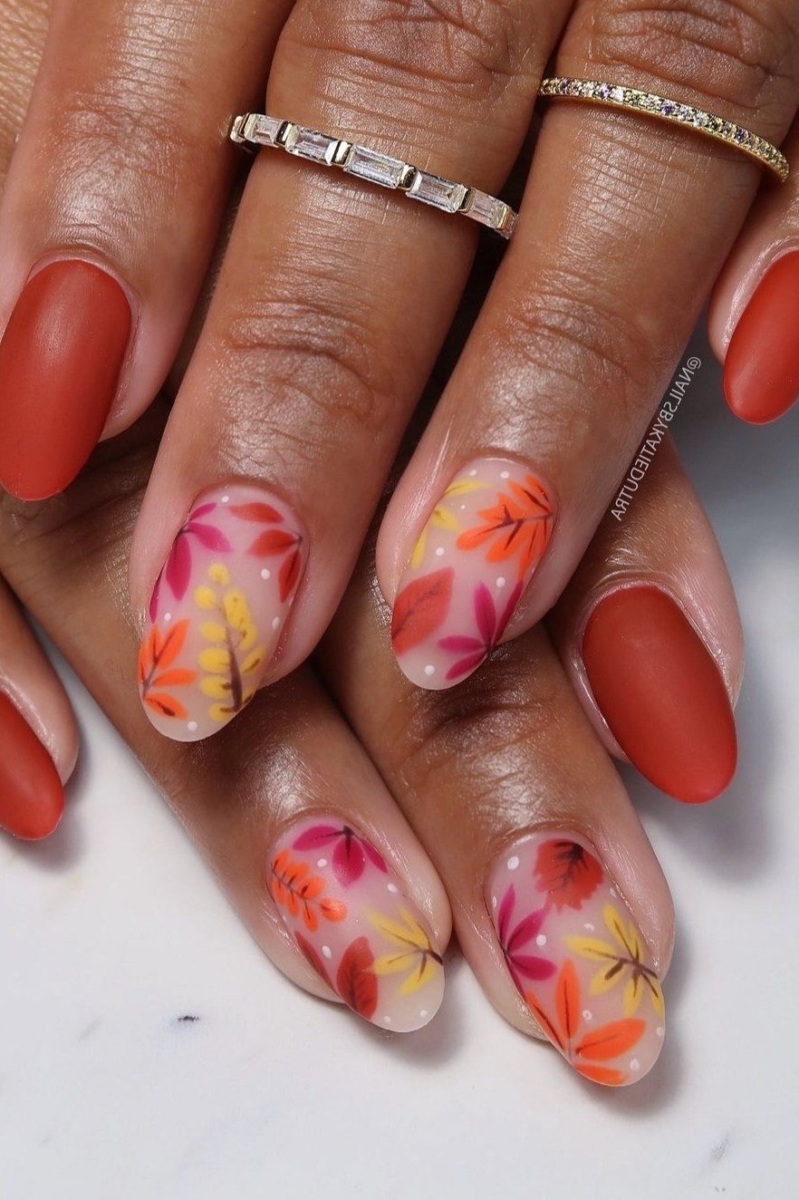 Terracotta red nails with floral art on dark skin, fall nail design for older women
