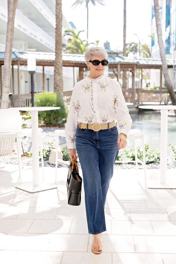 White eyelet blouse with flared jeans for women over 70