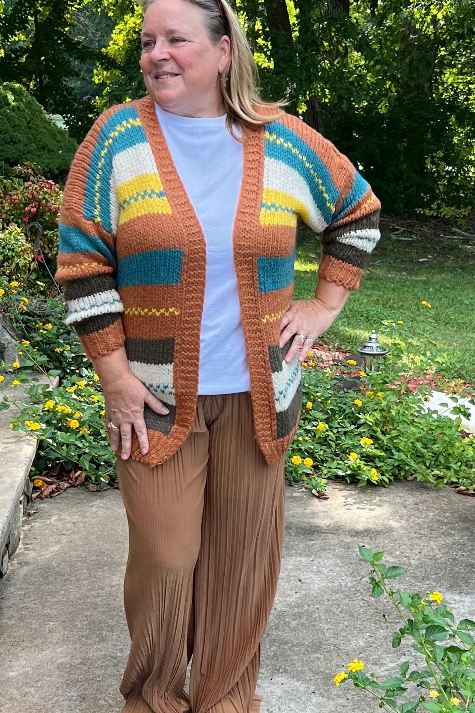 Colorful striped knit cardigan with white top and tan pants for women over 50