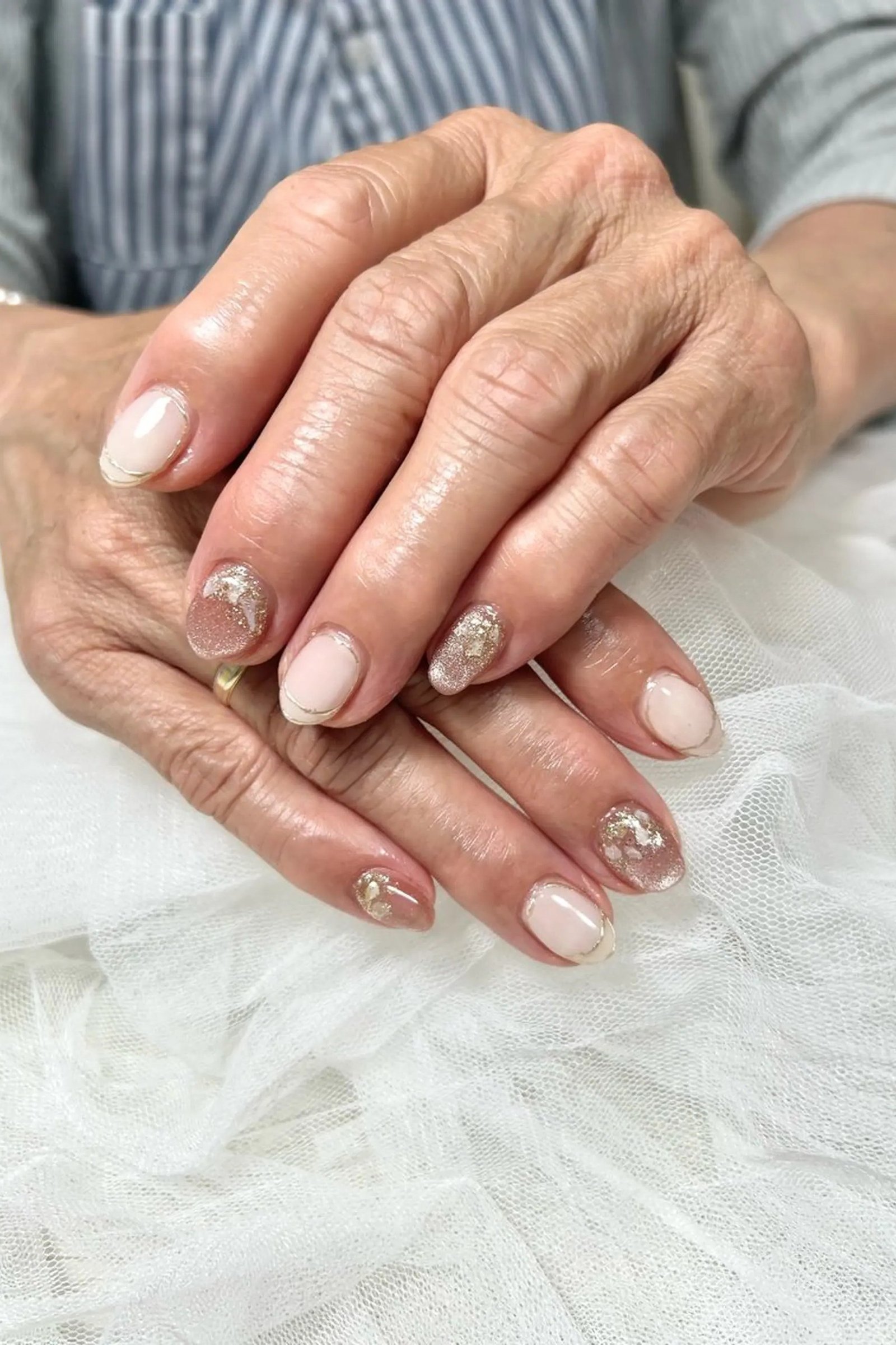 milky nude nails with gold glitter accents, soft gold glitter nail idea for older women