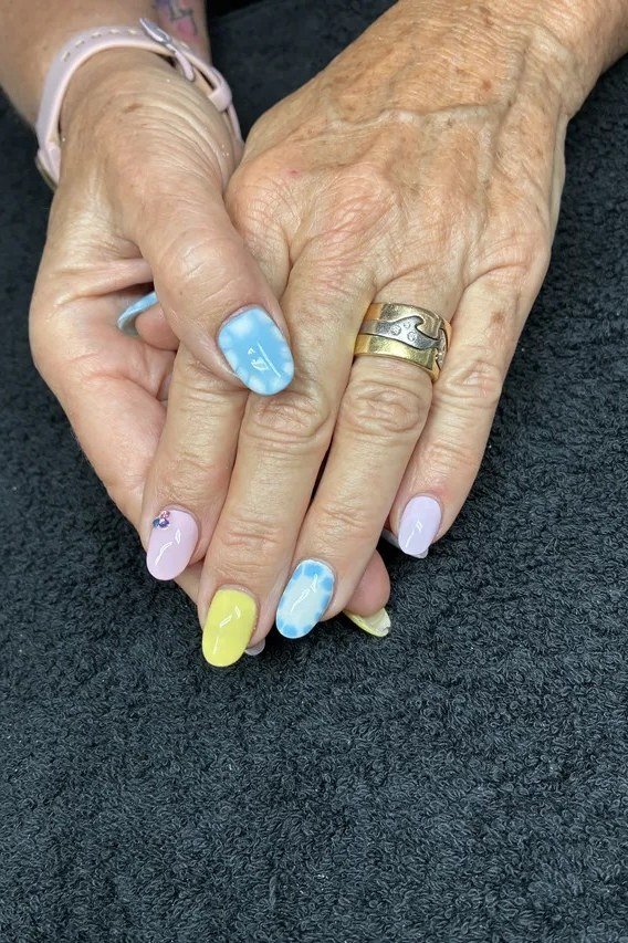 Pastel rainbow accent nails on elderly hands
