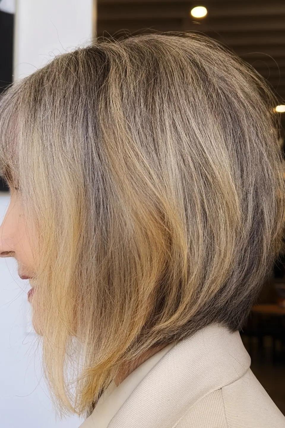 Blonde angled bob with a stacked back in side view for women over 60